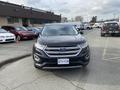 A black 2017 Ford Edge is parked facing forward with its headlights on and chrome grille visible