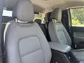 Two front seats of a 2017 Chevrolet Colorado with gray upholstery and a center console between them