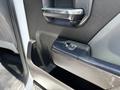 Close-up of the door panel of a 2020 Chevrolet Silverado showing the door handle and window control button