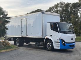 A 2022 Lion Lion6 electric truck with a white cargo box and blue accents parked at an angle, showcasing its modern design and smooth lines