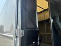 A 2018 Ford Econoline with an open door revealing the interior space and a dark seat next to the entrance