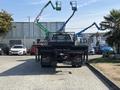 A 2018 Ford F-750 truck with a flatbed is parked facing away from the camera showcasing its rear and distinctive design features