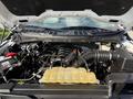 The engine compartment of a 2021 Ford F-150 featuring a V6 engine with a large air intake and a yellow coolant reservoir