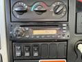 Interior dashboard controls of a 2012 International DuraStar 4300 featuring climate knobs a radio display and various buttons for vehicle functions