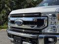Close-up of a 2021 Ford F-250 SD featuring a prominent chrome grille with the Ford logo and the words Super Duty embossed on the hood