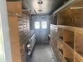 Interior view of a 2007 Morgan Olson Workhorse W42 featuring shelves and drawers for storage along both sides with empty space in the center and pipes arranged along one wall