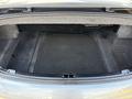 The open trunk of a 2004 BMW 6-Series showing a spacious interior with gray carpeting and no items inside