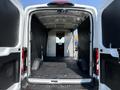 Interior view of a 2022 Ford Transit cargo van showing a spacious empty cargo area with black rubber flooring and side walls