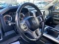 A black steering wheel with control buttons and a dashboard displaying gauges and a center console in a 2017 RAM 1500