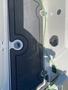 A close-up view of the deck area of a 2013 Larson 238 boat featuring a black mat and a silver latch with a green wire nearby