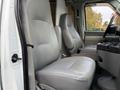 Interior of a 2008 Ford Econoline showing two light gray upholstered front seats with armrests and a central console between them