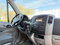 Interior of a 2016 Mercedes-Benz Sprinter featuring a steering wheel, dashboard controls, and a gear shift with a display screen