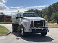 A 2016 Ford F-750 truck with a silver and black exterior featuring a large tank in the truck bed and multiple lights on the roof