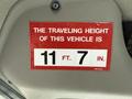 A red sticker displaying the traveling height of a 2011 International 4300 vehicle indicating 11 ft 7 in