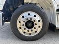 Close-up of a 2022 Freightliner M2 106 wheel featuring a shiny metallic rim with multiple lug nuts and a black tire labeled Conti Ecoplus HS3