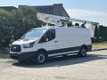 A 2019 Ford Transit 350 with a bucket lift attached on the roof parked on a concrete surface