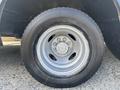Close-up of a tire mounted on a silver rim for a 2012 Ford E-450 with visible tread patterns and a distinct hubcap design