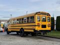 A yellow 2013 International 4300 school bus parked with multiple rows of windows and black accents on the bottom half of the vehicle