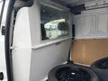 A 2019 Ford Transit Connect with a partition separating the front cabin from the cargo area displaying black tires stacked on the floor