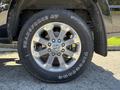 A close-up of a chrome alloy wheel on a 2021 RAM 3500 truck featuring a large tire with the text TRANSFORCE AT on the sidewall