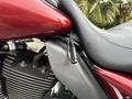 Close-up of a 2009 Harley-Davidson Road King showcasing the seat and fuel tank with shiny red paint and chrome accents