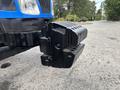 A black hitch attachment designed for a 2009 New Holland T4020 tractor with textured surfaces and mounting hardware visible