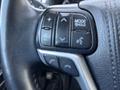 Close-up of the steering wheel controls of a 2018 Toyota Highlander including buttons for phone, mode, and volume