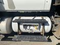 A large gray fuel tank mounted on a metal frame with two horizontal support brackets and a valve and connector on one side