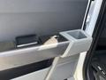 Close-up of a 2021 Ford F-150 door handle and armrest featuring a cup holder and a textured surface
