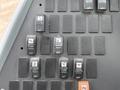 A dashboard panel featuring various switches labeled for functions like heater, mirror, lights, and pump on a 2013 International 4300