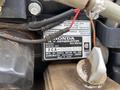 A 1994 GMC Vandura 3500 engine with a close-up of a Honda RV generator label detailing model and serial information