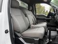 Interior view of a 2018 Ford F-550 showing the front seats with grey fabric upholstery and a center console area