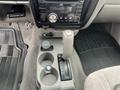Interior view of a 2004 Toyota Tacoma showing the gear shift, audio system, and center console with cup holders and controls
