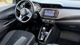 Interior view of a 2019 Nissan Kicks featuring a black steering wheel digital display and modern console with controls and a touchscreen navigation system