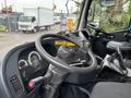 A close-up view of the steering wheel and dashboard of a 2017 Autocar Xpert showing gauges controls and a gear shift