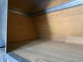 Interior of a 2016 Ford Transit van featuring wooden walls and a spacious, empty cargo area with a clear acrylic container on the floor