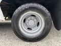 A close-up of a 2014 Ford E-350 wheel featuring a silver rim and a Nexen tire with a rugged tread pattern
