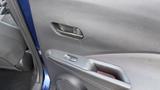 Interior door handle and armrest of a 2019 Nissan Kicks with a speaker and controls visible on the door panel