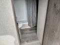The interior of a 2021 Jayco Jay Flight featuring a bathroom area with a shower curtain a toilet and wood-like flooring