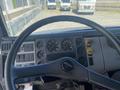 Interior view of a 1997 Freightliner FL70 truck featuring a steering wheel with a dashboard displaying various gauges and controls