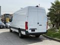 A white 2023 Mercedes-Benz Sprinter van is parked with its rear facing the viewer showcasing its smooth lines and modern design