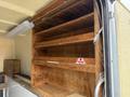 A 2008 Ford F-450 SD with a spacious, empty wooden shelf system inside its cargo area