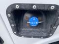 Close-up of a blue cap labeled Diesel Exhaust Fluid on a 2015 Ford F-550 with visible mounting screws and a metal handle