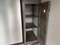 An open storage cabinet with three shelves and a door, made of wood with a metallic finish, part of a 2021 Jayco Jay Flight camper interior