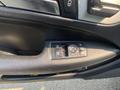 Close-up of a control panel on the driver's door of a 2013 Mercedes-Benz C-Class featuring window controls and a circular adjuster knob