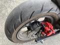 Close-up of a 2018 Honda Grom rear tire and brake system showcasing the textured tire and red brake caliper