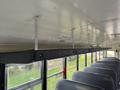 Interior view of a 2013 International 4300 school bus showing ceiling and empty seats with a storage area along the top