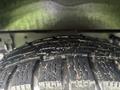A close-up view of a tire from a 2021 Ford Transit-350 displaying deep treads and wear patterns on its rubber surface