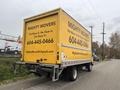 A 2019 Hino 155 box truck with a bright yellow rear featuring the company name Mighty Movers and contact information in black letters