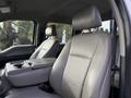 Interior view of a 2020 Ford F-550 showing two front seats with gray upholstery and a center console between them